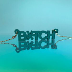 goudkleurige ketting met een doorzichtige donker groene hanger die b*tch zegt